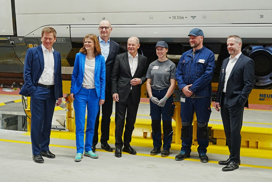im Bild (v.l.n.r.): Richard Lutz, Vorstandsvorsitzender Deutsche Bahn; Daniela Gerd tom Markotten, Vorstand Digitalisierung und Technik Deutsche Bahn; Dietmar Woidke, Ministerpräsident Brandenburg; Olaf Scholz, Bundeskanzler; DB Werksmitarbeitende; Marc Hermann, Gesamtprojektleiter Werk Cottbus