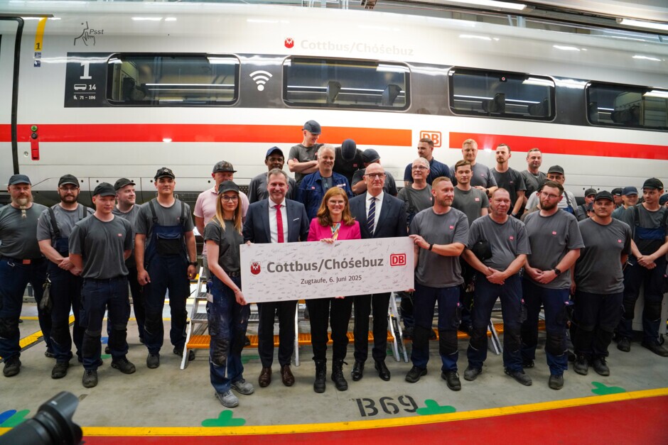 Cottbus/Chóśebuz, 6. Juni 2025 – Stolze 22 Jahre war ein ICE 2 der Deutschen Bahn (DB) mit Wappen und Namen der Stadt Cottbus auf Deutschlands Schienen unterwegs. Jetzt übernimmt ein hochmoderner zwölfteiliger ICE 4 der DB die Aufgabe des rollenden Botschafters für die Stadt am Rande des Spreewalds. Regionaltypisch mit Spreewälder Gurkenwasser wurde der ICE-Triebzug 9009 (ICE 4 Baureihe 412) im neuen Werk der DB in Cottbus/Chóśebuz getauft. Brandenburgs Ministerpräsident Dr. Dietmar Woidke, der Cottbuser Oberbürgermeister Tobias Schick, Dr. Daniela Gerd tom Markotten, DB-Vorständin für Digitalisierung und Technik, und Angelina Tantow, Fahrzeuglackiererin in Ausbildung im neuen Werk Cottbus, enthüllten gemeinsam das Stadtwappen und Schriftzug „Cottbus / Chóśebuz“.